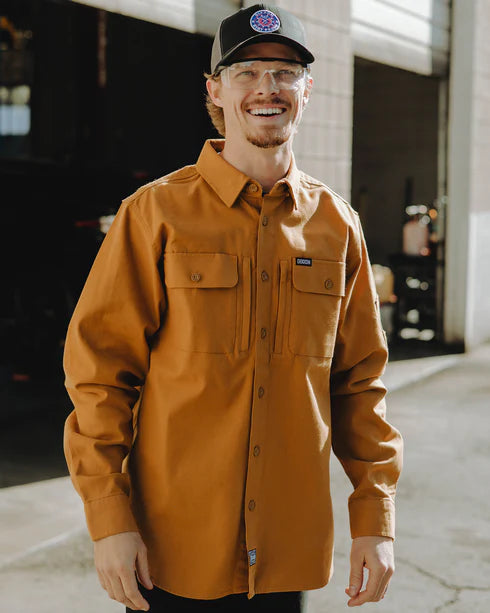 MEN'S LONG SLEEVE WORK SHIRT (Camel) | DIXXON model smiling outdoors, showcasing style and durability for work.