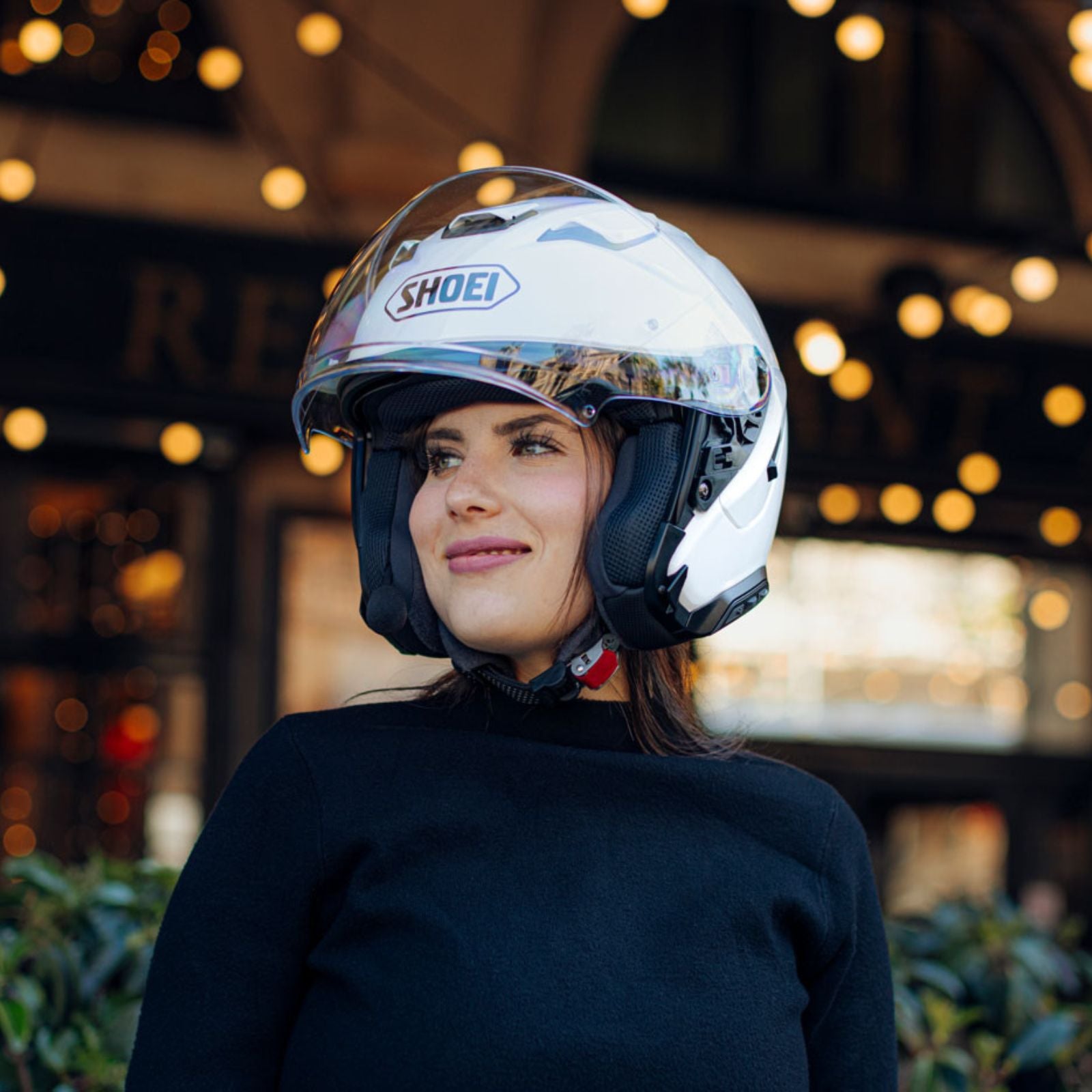 J-CRUISE 3 OPEN FACE HELMET (White) | SHOEI worn by a woman outdoors with decorative lights in the background.