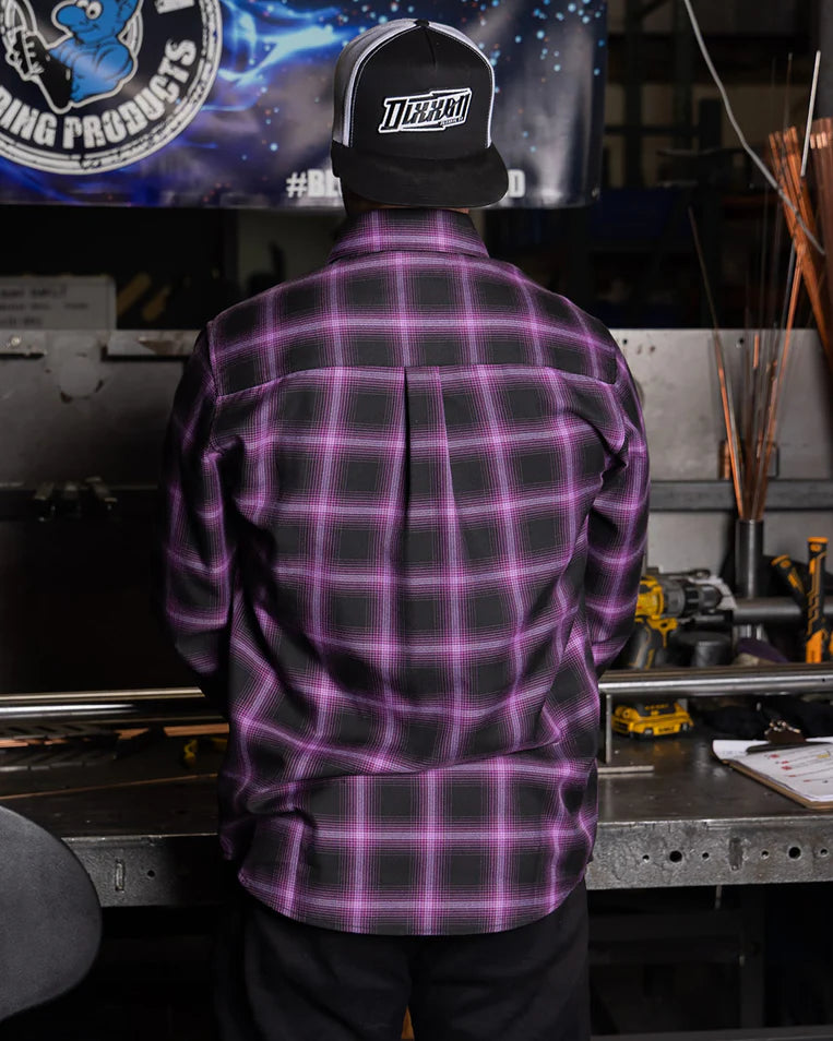 MEN'S ARGON FLANNEL (Purple/Black) | DIXXON worn from the back, showcasing the plaid pattern in a workshop setting.