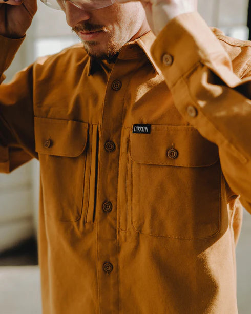 MEN'S LONG SLEEVE WORK SHIRT (Camel) | DIXXON being worn by a person, showcasing its durable fabric and stylish design.
